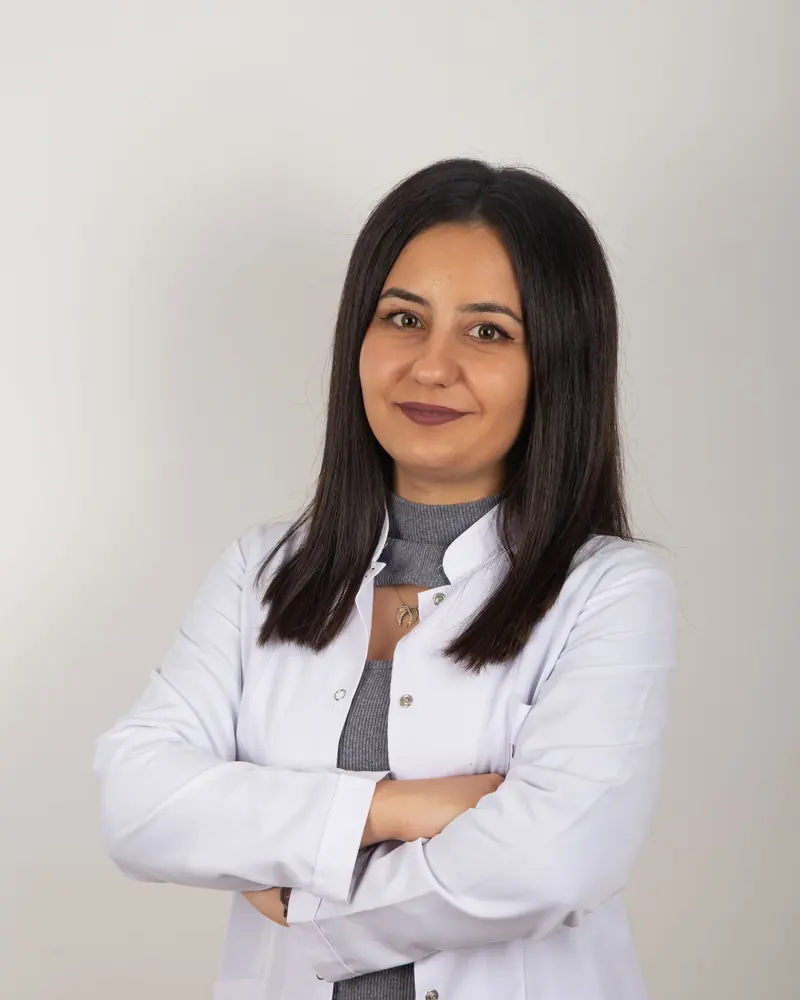 Dr. Alexandra Morgan, lead chiropractor, standing in a white coat with arms crossed