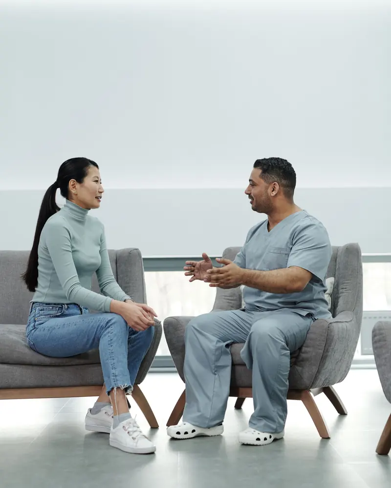 Two people talking in armchairs in a bright, quiet room